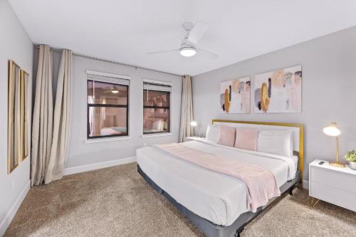 ein Schlafzimmer mit einem großen Bett und zwei Fenstern in der Unterkunft Gated community 4BD townhouse next to Disney in Kissimmee