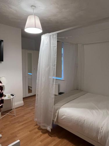 una camera con un letto a baldacchino bianco di The Cotton Mill Hideaway a Manchester