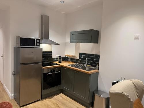 杜埃La Location des géants - Appartement avec terrasse的厨房配有不锈钢冰箱和水槽