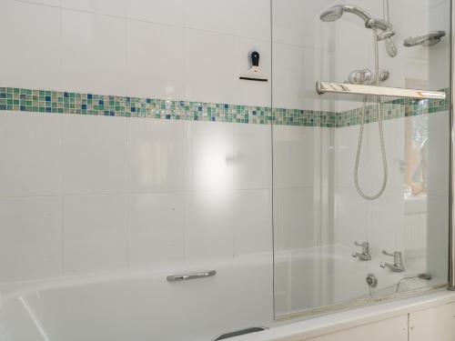 a bathroom with a shower with a glass door at Keepers Cottage in Warminster