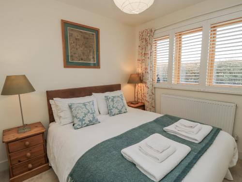 a bedroom with a bed with two towels on it at Keepers Cottage in Warminster