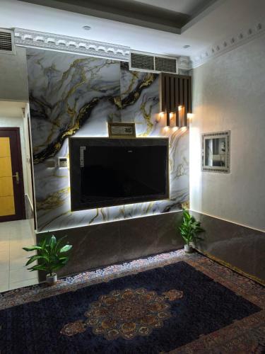 a large flat screen tv on a wall in a lobby at Furnished 1bhk with all needs in Ajman
