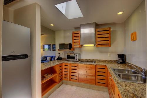 a kitchen with wooden cabinets and a sink at Riviera Maya Suites in Playa del Carmen