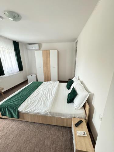 a bedroom with a large bed and a table at Casa Venus in Sînmartin
