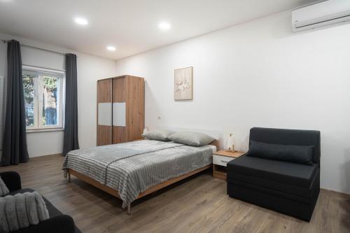 a bedroom with a bed and a chair at Studio apartman MALA OAZA in Kistanje