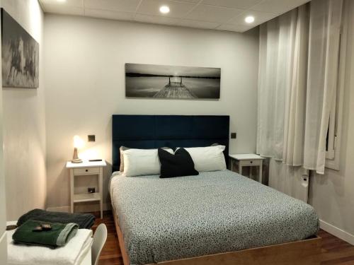 a bedroom with a bed with a blue headboard at Pensión Guggenheim Riverview HBI01297 in Bilbao