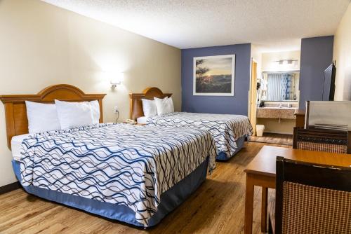 a hotel room with two beds and a table at Boerne Inn and Suites in Boerne