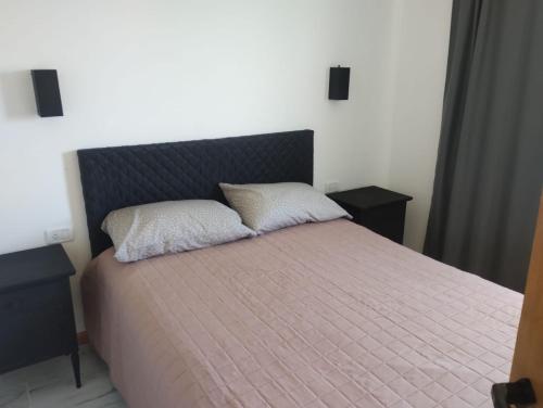 una camera da letto con un letto con due cuscini sopra di Cabañas ohana a Camet Norte