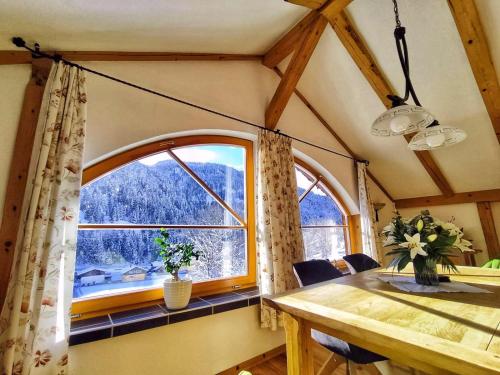 WildenHaus Älpele的带桌子和大窗户的餐厅
