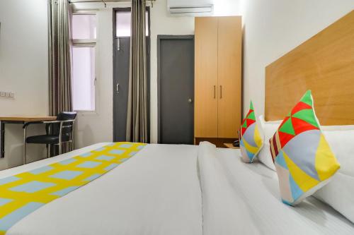 HasanganjSuper Hotel O Basera Homes Jankipuram的卧室配有一张带彩色枕头的大型白色床。