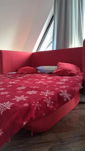 a red bed in a room with a window at Diamond Magic 2 Divcibare in Divčibare