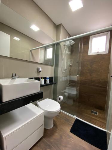 a bathroom with a shower and a toilet and a sink at Congresso ou maratona, studio central, com garagem in Florianópolis