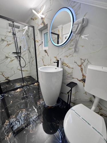 bagno con servizi igienici e specchio di PENSIUNEA MIHAELA-Transalpina a Novaci-Străini