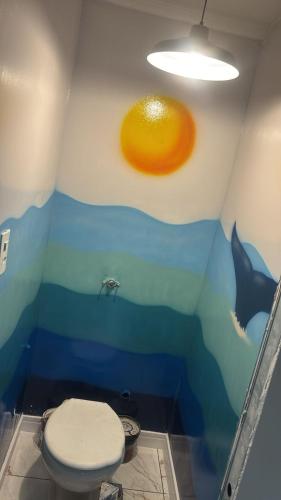a bathroom with a dolphin and a toilet in a room at Casa ao mar -Pousada Itapema in Itapema