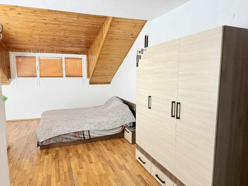 a bedroom with a bed and a large cabinet at Cozy two room maisonette apartment in Samokov