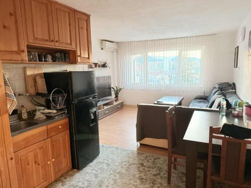 a kitchen and living room with a black refrigerator at Cozy two room maisonette apartment in Samokov