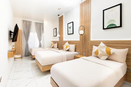 a hotel room with two beds and a television at Hotel H4 Olanchito in Olanchito