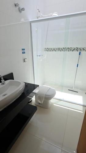 a white bathroom with a sink and a toilet at Vila das Marés Beach Hotel in São Sebastião