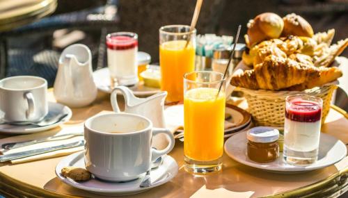 a table with a breakfast of coffee and orange juice at DREAM ISLAND studios & apartments with POOL Playa LOS CORALES in Punta Cana