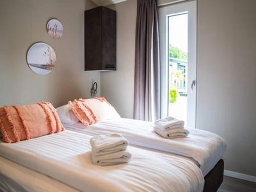 费尔德霍芬Chalet by Park Pond in the Netherlands的一间卧室，有两张床，床上有毛巾