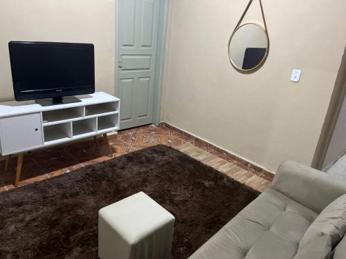 a living room with a couch and a tv at Casa aconchegante a poucos passos da Basílica in Aparecida