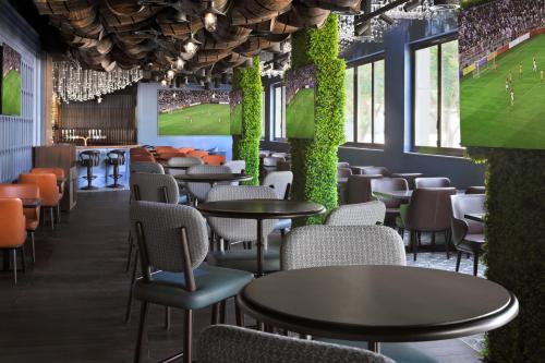 a restaurant with tables and chairs and a football game on the wall at Holiday Inn Express Dubai Internet City by IHG in Dubai