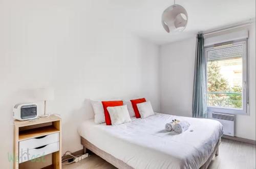 Perollier - CI - Lyon 2 - Bedroom apartment with balcony and pool في إيكولي: غرفة نوم بها سرير مع وسائد حمراء ونافذة