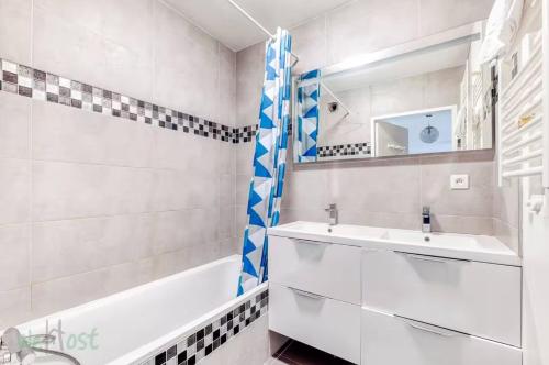 Perollier - CI - Lyon 2 - Bedroom apartment with balcony and pool في إيكولي: حمام مع حوض استحمام ومغسلة وحوض استحمام