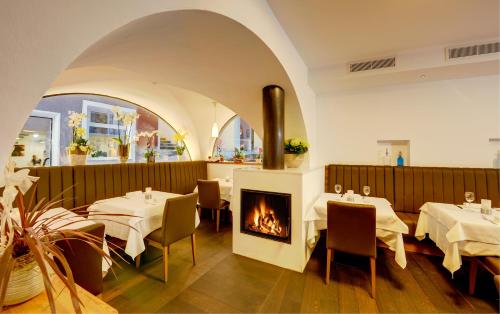 un ristorante con due tavoli e un camino di Restaurant Sigmund B&B a Merano