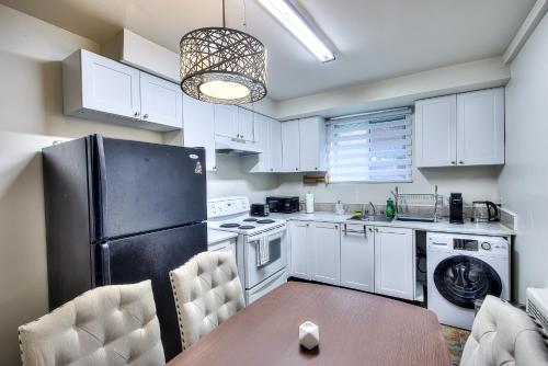 a kitchen with white cabinets and a black refrigerator at Cute & Cozy Hub for Montreal Travelers in Montréal