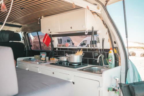a kitchen in an rv with a stove and a sink at Mini Camper Van Hot Water, You Can Drive it in Telde