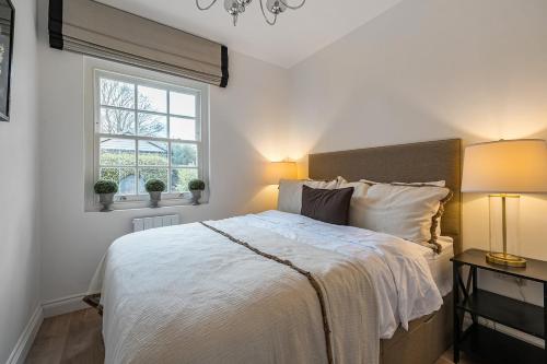 巴斯The Coach House at The Grange的一间带床和窗户的白色卧室