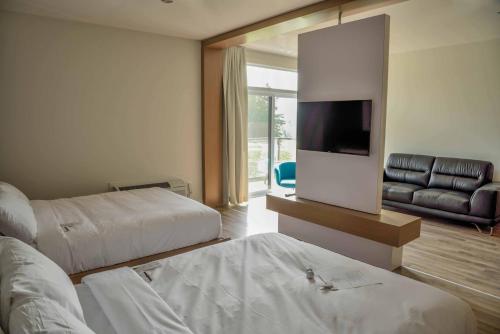 a hotel room with two beds and a flat screen tv at La Cache du Golf in Beauceville