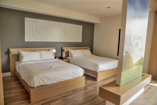 two beds in a hotel room with at La Cache du Golf in Beauceville