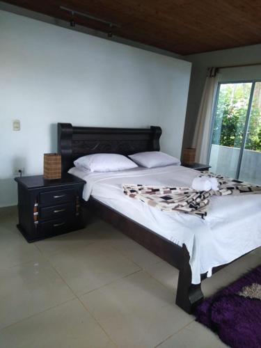 a bedroom with a large bed and a window at Hostal Hilltop Capurgana in Capurganá