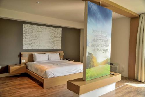 a bedroom with a bed and a large screen at La Cache du Golf in Beauceville