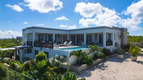 a house on the beach with a swimming pool at Zirok Villas in The Valley