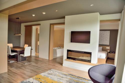 a living room with a fireplace and a tv on a wall at La Cache du Golf in Beauceville