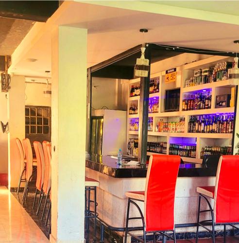 a bar with red chairs in a restaurant at STERLEON HOTEL RIVERSIDE in Nairobi