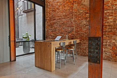 a kitchen with a wooden counter and a brick wall at Sosuite at The Queen - Queen Village in Philadelphia
