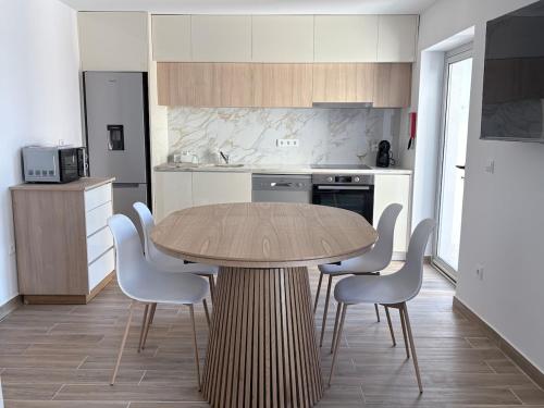 a kitchen with a wooden table and chairs at Figueira Guesthouse in Figueira da Foz