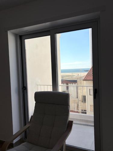a chair sitting in front of a window at Figueira Guesthouse in Figueira da Foz