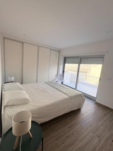 a bedroom with a large bed and a chair at Figueira Guesthouse in Figueira da Foz