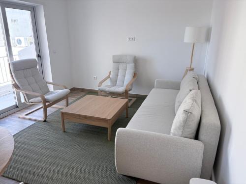 a living room with a couch and two chairs at Figueira Guesthouse in Figueira da Foz