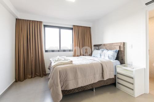 a white bedroom with a bed and a window at Cozy 2 Br In Ciudad Del Este in Puerto Presidente Franco