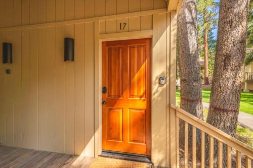 een houten voordeur van een huis met een boom bij Kings Beach Luxe in Wood Vista