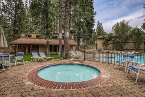 een zwembad in een tuin met stoelen en een hek bij Kings Beach Luxe in Wood Vista