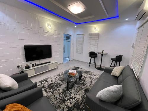 een woonkamer met een bank en een flatscreen-tv bij Luxury Stay in Lagos in Iju Junction
