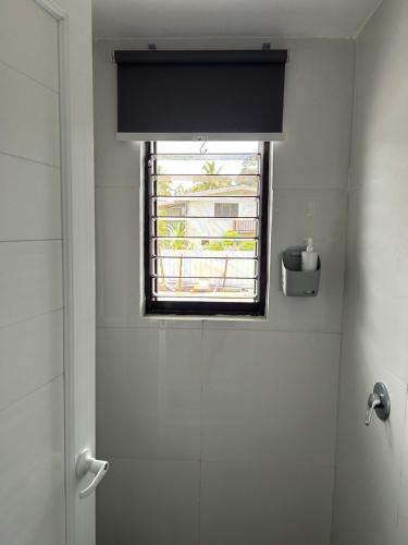 a bathroom with a window and a shower stall with a shower at Residence 50 Apartment Nausori in Nausori