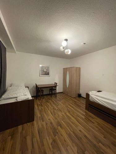 a room with two beds and a table in it at Hostel Casa Andalucia in Hallbergmoos